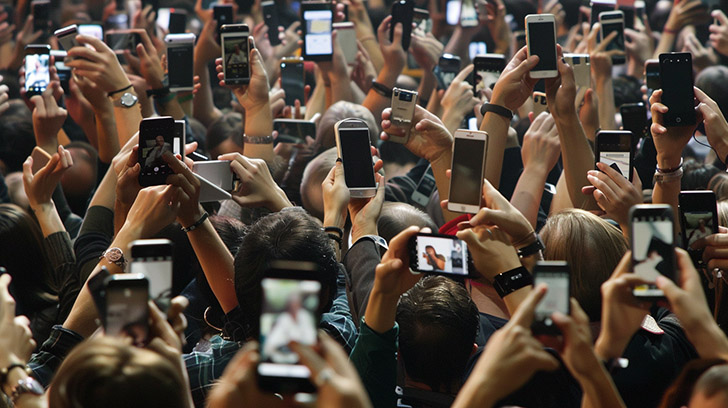 A crowd holding smartphones